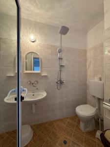 a bathroom with a toilet and a sink and a shower at Hotel Laguna - Guest House in Primorsko +28 photos