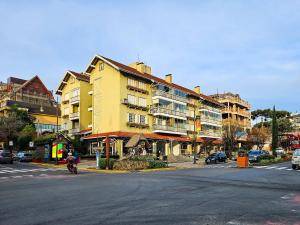 a yellow building on the side of a street at Ap 2 quartos e varanda na Borges próximo R Coberta in Gramado