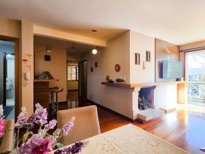 a living room with a fireplace and a dining room at Ap 2 quartos e varanda na Borges próximo R Coberta in Gramado
