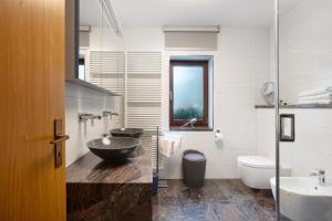 a bathroom with two sinks and a toilet at Amadeus Black Forest Mountain in Todtmoos +29 photos
