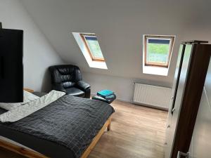 a bedroom with a bed and a black chair at Casa Pedro in Osnabrück