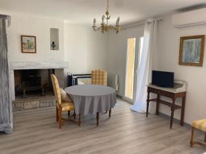 a living room with a table and chairs and a television at Maison Sainte Catherine in Les Salles-sur-Verdon