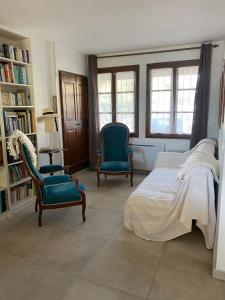 a bedroom with two chairs and a bed and bookshelves at Maison Sainte Catherine in Les Salles-sur-Verdon