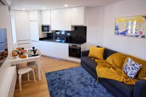 a living room with a couch and a table and a kitchen at Mponto in Ponte da Barca