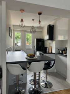 a kitchen with a island with bar stools and a sink at Appartement chaleureux et spacieux T3 in Limoges