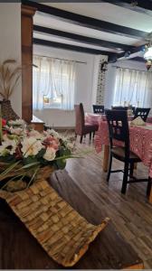 a living room with a table with flowers on it at Pensiunea Casa Godja in Văleni +20 photos