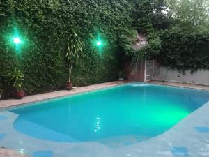 a swimming pool at night with two green lights at Managua Inn in Managua