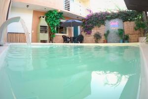カボ・フリオにあるCasa aconchegante! perto de Búzios e Cabo Frioの家の前にある噴水付きのプール