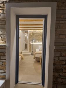 a door leading into a bedroom with a mirror at Golden Star in Ios Chora