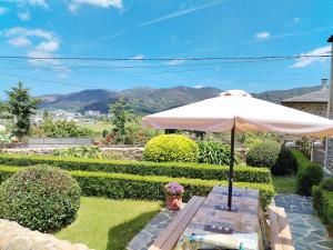 a white umbrella sitting on top of a yard at Casa Lolita 1 in Viveiro