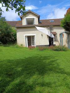 an old house with a large yard with a window at La petite maison in Sainte-Gemme-Moronval