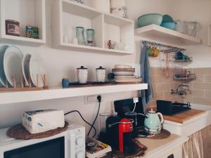 a kitchen with a microwave on a counter at La casa del glicine Marrubiu in Marrùbiu +26 photos