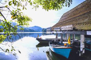 due barche sono attraccate accanto a un edificio su un lago di Kandy Siebel Bungalow a Kandy