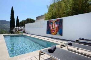 una piscina con un dipinto sul lato di un edificio di K-Sea Villa Boutique De Luxe à Cassis a Cassis