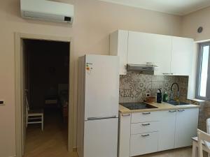 a kitchen with white cabinets and a white refrigerator at Montanara3 in Parma