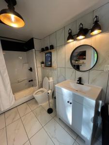 a bathroom with a sink and a toilet and a mirror at Rester Vivant Chambres d'hôtes in Saint-Jean-Port-Joli