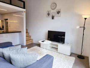 a living room with a blue couch and a tv at The Establishment Bangsar in Kuala Lumpur