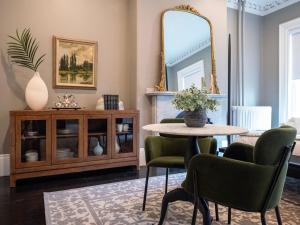 a dining room with a table and chairs and a mirror at The Chester Hotel in Boston