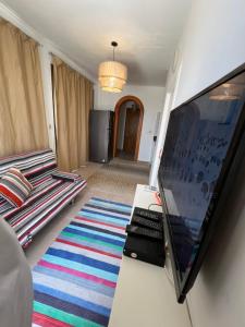 a living room with a flat screen tv and a couch at Marassi Lovely Top Roof Chalet in El Alamein