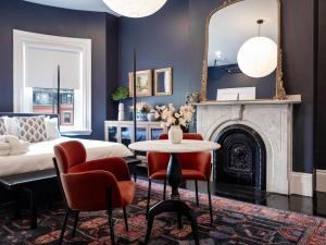 a bedroom with a bed and a mirror and a table at The Chester Hotel in Boston