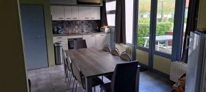 a kitchen with a wooden table and chairs in it at Duinengolf 37 in Middelkerke