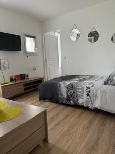 a bedroom with a bed and a flat screen tv at La petite maison de la gare in Nemours
