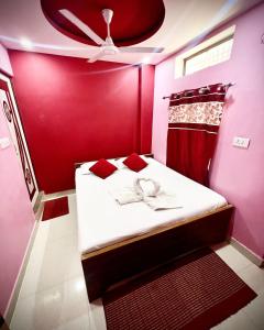 a red room with a bed with a ceiling at Maa Durga Inn in Varanasi