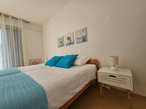 ein Schlafzimmer mit einem Bett mit blauen Kissen in der Unterkunft Gianna Apartment Labin in Labin