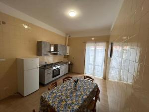 a small kitchen with a table and a refrigerator at Casa Vacanza SOFIA in Ravello