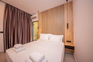 a bedroom with a bed with white towels on it at Vila Olserd Shehu in Ksamil
