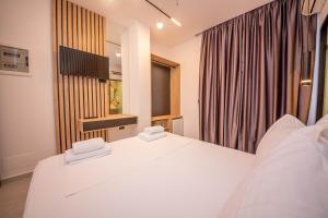 a bedroom with a white bed and a window at Vila Olserd Shehu in Ksamil