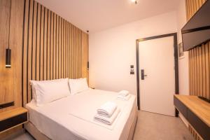 a bedroom with a white bed with towels on it at Vila Olserd Shehu in Ksamil