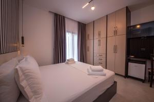 a bedroom with a large white bed and cabinets at Vila Olserd Shehu in Ksamil