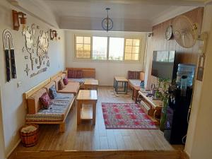 a living room with couches and tables in a room at Champollion Hostel in Cairo