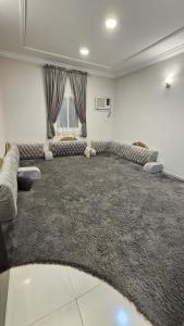 a large living room with a large rug at شقق سكنية مفروشة بالباحة 1 in Al Jith