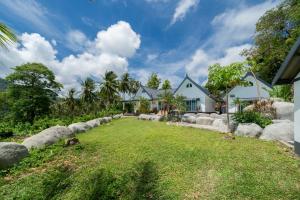 a house with a yard with rocks at Villa Olympus Sea View Private Pool 4BR Near Kata Beach in Kata Beach