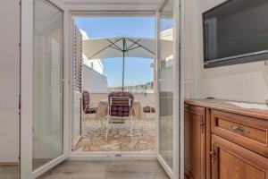 a glass door leading to a patio with a table and chairs at Seafront apartments Marija with terrace and mooring in Rogoznica +62 photos