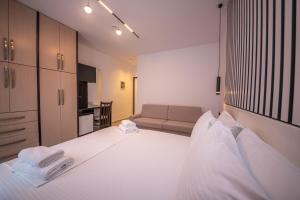 a bedroom with a large white bed and a couch at Vila Olserd Shehu in Ksamil