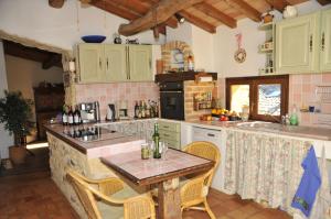 a kitchen with green cabinets and a table with chairs at Maison L'Authentique in La Capelle-et-Masmolène +29 photos