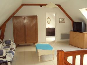 a living room with a couch and a tv at Villa Le Clos de Mosny in Amboise