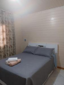 a bedroom with a bed with two towels on it at Super Casa de 3 Quartos ao Lado da Igreja Matriz in Urubici