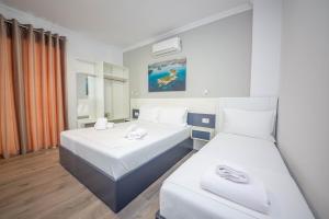 a hotel room with two beds and a window at Vila Olserd Shehu in Ksamil
