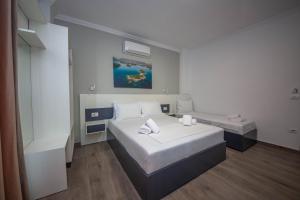 a hotel room with two beds and a window at Vila Olserd Shehu in Ksamil