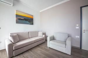 a living room with a couch and a chair at Vila Olserd Shehu in Ksamil