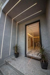 a building with two potted plants in front of a window at Vila Olserd Shehu in Ksamil