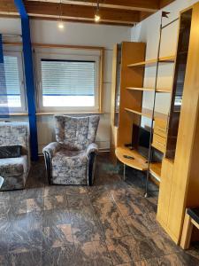 a living room with a chair and a television at Haus mit Aussicht S3-Bahn, B14-Straße, WLAN in Schwaikheim