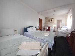 a white room with two beds and a bathroom at Ambient Apartments in Struga
