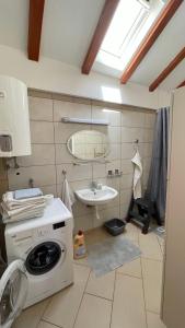 een badkamer met een wasmachine en een wastafel bij Apartman Belamaric in Šibenik