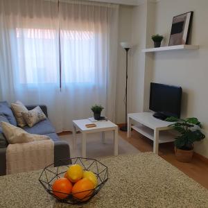 una sala de estar con una mesa con un bol de naranjas en MARALES Sanxenxo, en Sanxenxo