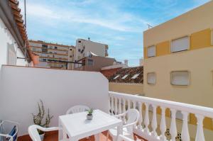a balcony with a white table and white chairs at El Atico de Andrea in Torre del Mar